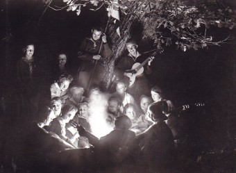 Wandervogel: Jungen und Mädchen am Feuer Eine Gruppe junger Wandervögel, die um ein Lagerfeuer herum sitzt, lacht und musiziert
