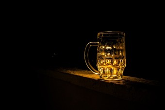 Ein Bierglas vor dunklem Hintergrund, dass beleuchtet ist